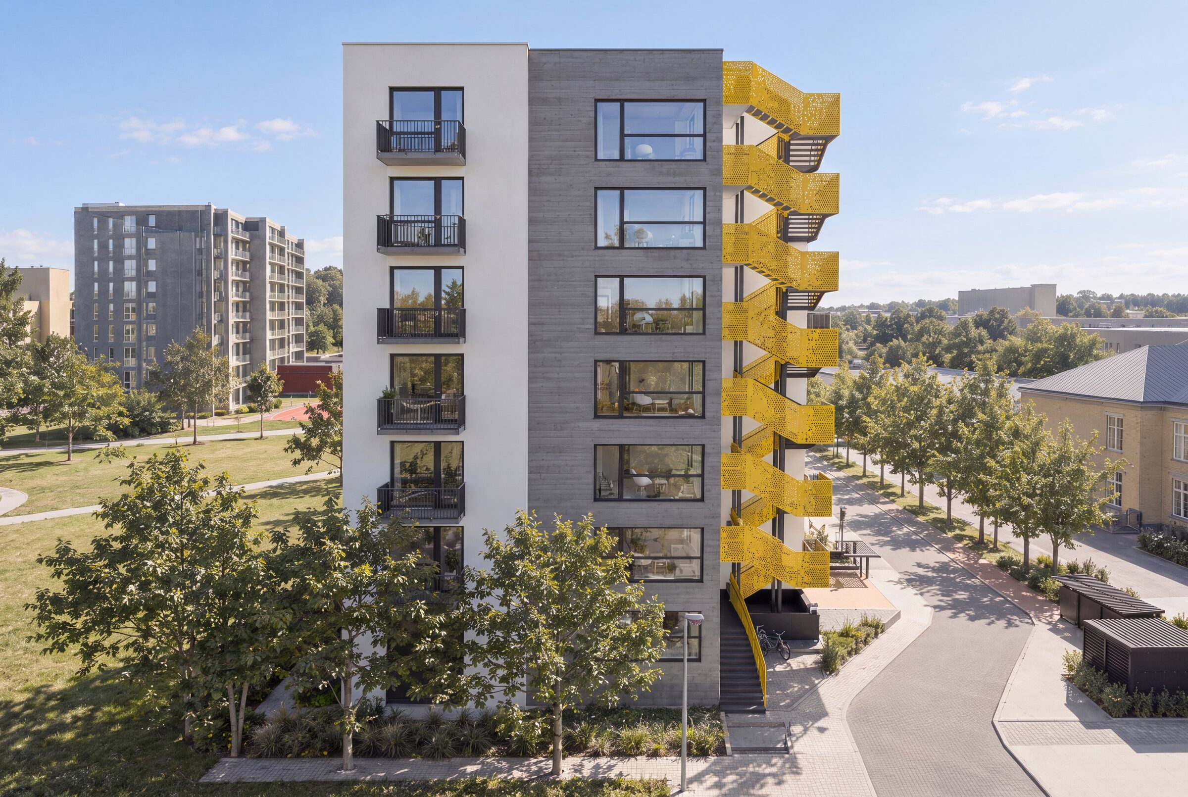 Vizualizace čelní fasády s betonovou věží a žlutým schodištěm